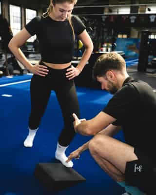 Frau beim Training mit Therapeut von PhysioSport Köln. Das Training dient der Verbesserung von richtiger Fussstellung.
