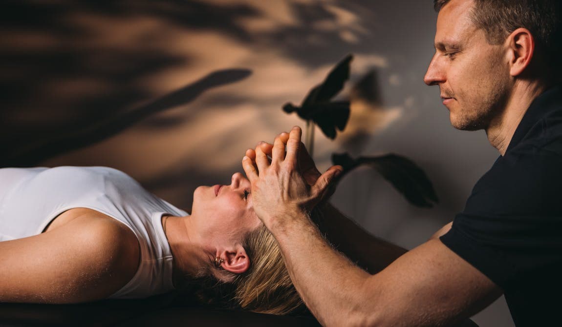 Zu sehen ist eine Patientin von schräg seitlich mit einem Physiotherapeuten während einer CMD Behandlung bei PhysioSport Köln.