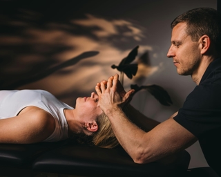 Zu sehen ist eine Patientin von schräg seitlich mit einem Physiotherapeuten während einer CMD Behandlung bei PhysioSport Köln.