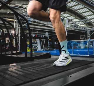 Mann auf einem Laufband, die Beine werden gezeigt.