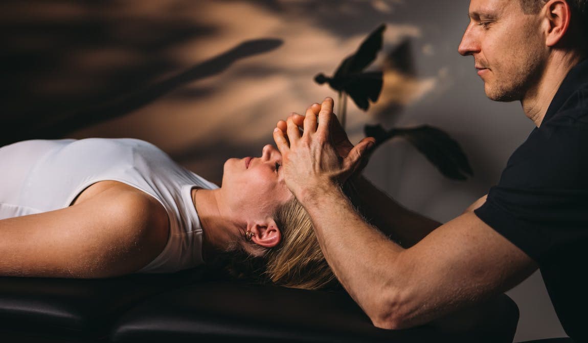 Trainer mobilisiert Hüftmuskulatur einer Patientin bei PhysioSport Köln.