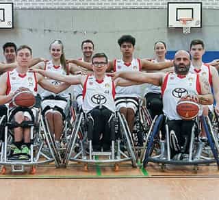Zu sehen ist ein Gruppenfoto mit 12 Personen einer gemischten Mannschaft der Köln 99ers, den Partnern von Physiosport Köln.