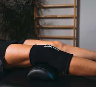 PhysioSport Köln: Kältebehandlung am Knie einer Patientin zur Schmerzlinderung in der Physikalischen Therapie.