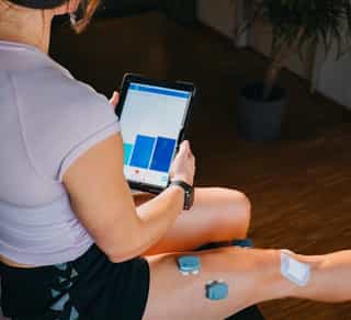 Physikalische Therapie mit EMG bei PhysioSport: Patientin mit Elektroden am Oberschenkel.
