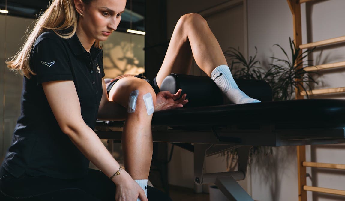 Physiotherapeutin von PhysioSport Köln behandelt Knieverletzung in der Rehaphase einer Patientin.