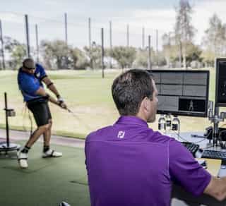 Zu sehen ist ein Golfspieler und ein externer Trainer beim Training auf einer Golfanlage zur Verbesserung seiner Leistung mittels TPI-Golfscreening durch PhysioSport Köln.