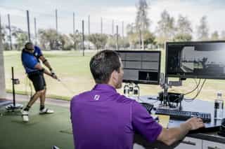 Zu sehen ist ein Golfspieler und ein externer Trainer beim Training auf einer Golfanlage zur Verbesserung seiner Leistung mittels TPI-Golfscreening durch PhysioSport Köln.