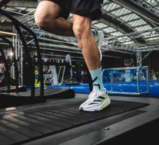 Zu sehen ist ein Sportler auf einem Laufband bei Physiosport Köln. In Nahaufnahme das Knie.