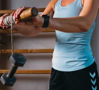 Zu sehen ist eine Sportlerin bei Übungen gegen Tennisellenbogen in den Räumen von PhysioSport Köln.