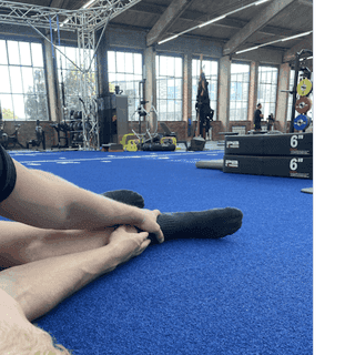 Sportler liegt am Boden bei PhysioSport Köln und fasst sich mit der Hand an seine Achillessehne.