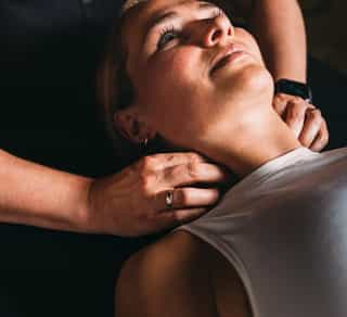 Physiotherapeutin von PhysioSport Köln behandelt eine Sportlerin an Triggerpunkten im Halsbereich.