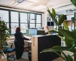 Zu sehen sind offene Büros und Mitarbeiter:innen von PhysioSport Köln im Headquarter in Köln Mülheim.