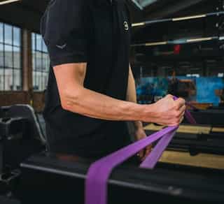 Sportler bei speziellen Übungen gegen Tennisellenbogen in Trainingsräumen bei PhysioSport Köln.