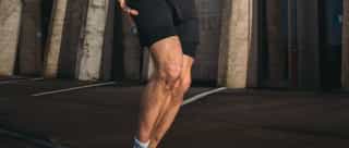 Sportler beim Laufen mit Laufschmerz im Knie.