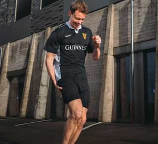 Sportler beim Laufen mit Laufschmerz im Knie.